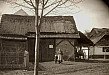 Na snímku ze 20. let 20. století vidíme stodolu, jež kdysi stávala na návsi a patřila k domku č.p. 16. V popředí stojí majitelka č.p. 16 paní Barbora Nová s vnukem, která v roce 1925 obci stodolu i se zahrádkou prodala a obec ji zbourala.